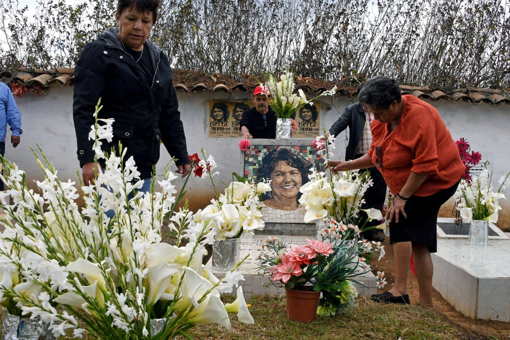 Relatives and friends place flowers at indigenous environmentalist Berta Caceres grave in La Esperanza, Honduras, on March 3, 2018.  Relatives and indigenous people demanded justice to the intellectual authors of the murder of the prestigious environmentalist Berta Caceres, executed two years ago for opposing the construction of a hydroelectric dam on a river. / AFP PHOTO / Orlando SIERRA        (Photo credit should read ORLANDO SIERRA/AFP via Getty Images)