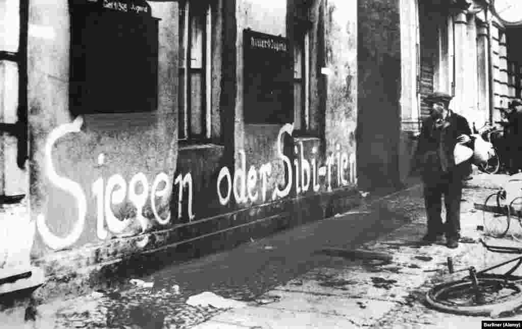 A German man looks at the phrase &ldquo;Victory or Siberia&rdquo; painted on a building. For many who remained, the grim maxim proved accurate. Millions of Germans were shipped east by the Soviets and some 357,000 died in labor camps or secret police prisons. &nbsp;