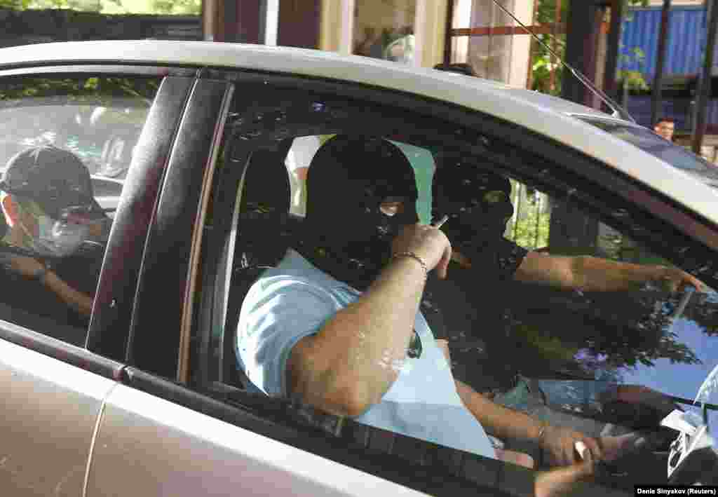 Masked men drive away after searching Navalny&rsquo;s Moscow office on June 12, 2012. Navalny was later summoned for questioning by police, which prevented his participation in a planned protest.