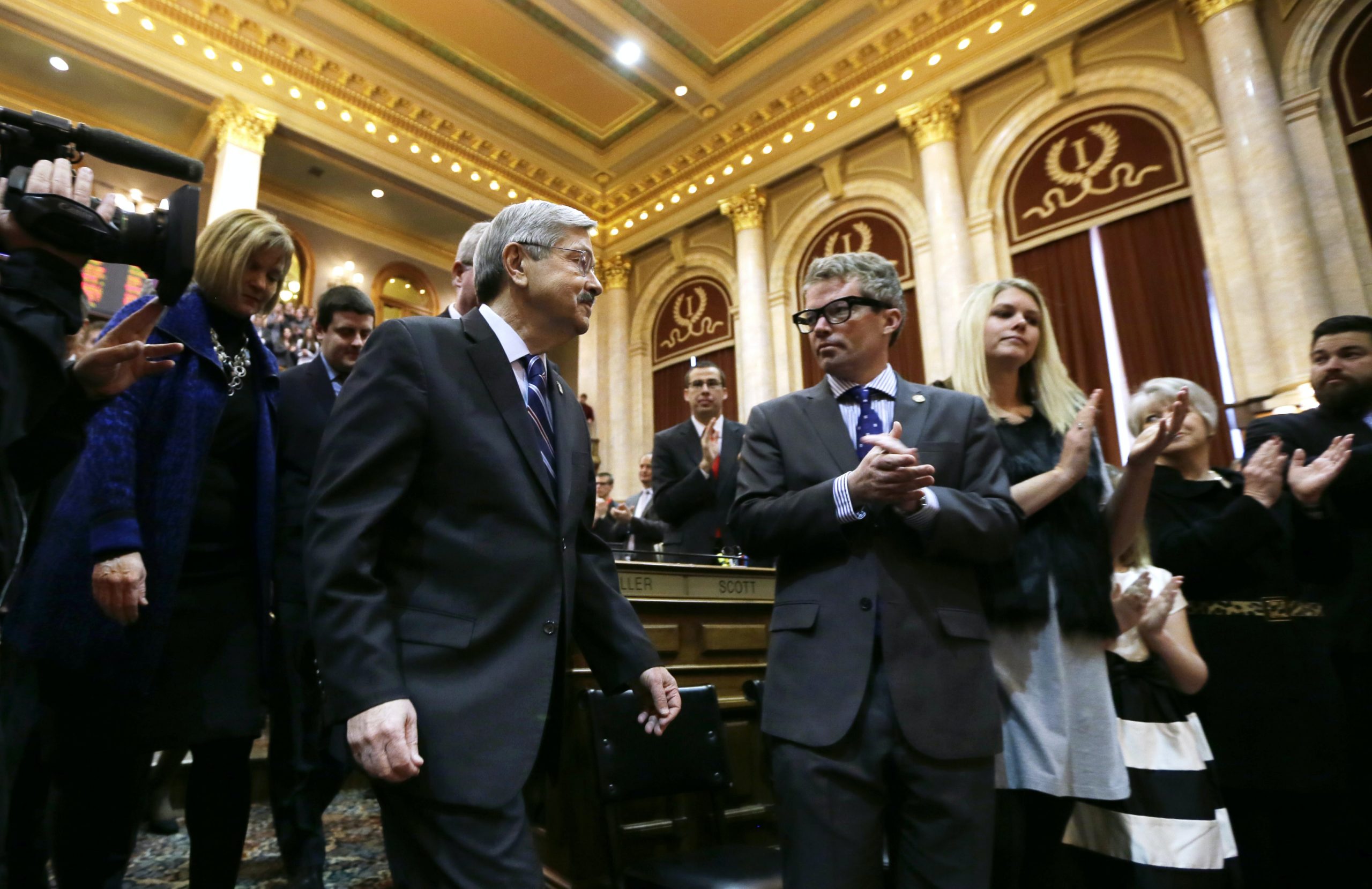 Iowa Gov. Terry Branstad, left, walks past his son Eric at the Statehouse in Des Moines, Iowa, on Jan. 12, 2016.