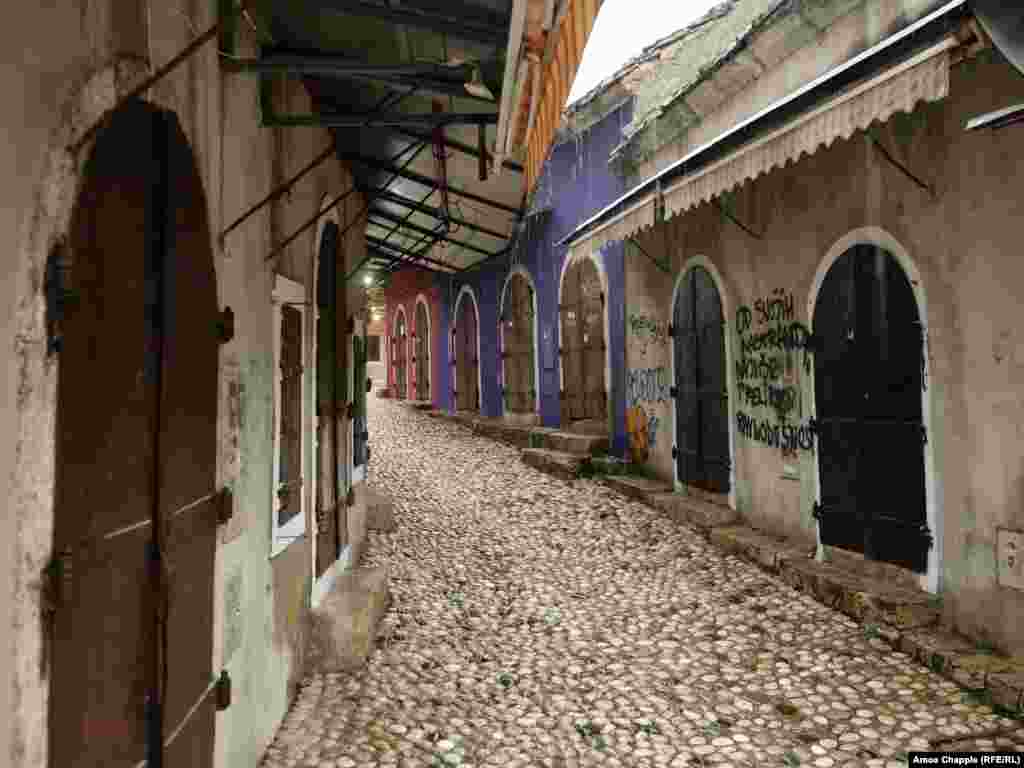 Shuttered stalls next to Mostar&rsquo;s old bridge in the early afternoon. The graffiti says &quot;Of all my quirks, I most despise indifference.&quot;&nbsp;&nbsp; &nbsp; Bosnia&rsquo;s new government will also be tasked with the fixing the enormous damage done to Mostar&rsquo;s once bustling tourist trade as a result of the COVID pandemic. &nbsp;