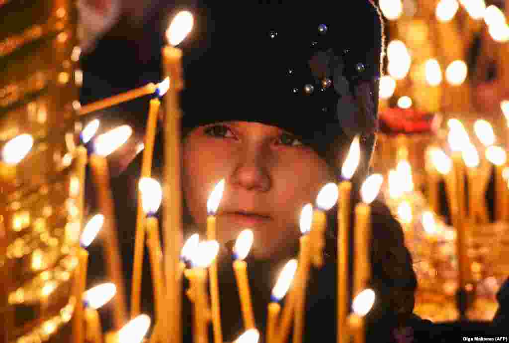 A girl lights a candle during a Christmas service in the Kazan Cathedral in St. Petersburg, Russia.&nbsp;