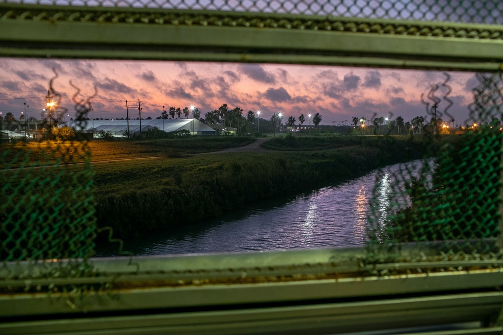 MATAMOROS, MEXICO - DECEMBER 09: U.S. government border facilities, including an immigration court, can be seen in Brownsville,  Texas from the international bridge over the Rio Grande on December 09, 2019 in the border town of Matamoros, Mexico. More than 1,000 Central American and Mexican asylum seekers have been staying, many for months, in a squalid camp, located next to the bridge in Matamoros, Mexico. Immigrant families at the camp are now required by the U.S. government to stay in Mexico as part of the Trump Administration's "Remain in Mexico" process for people legally seeking political asylum in the United States.  (Photo by John Moore/Getty Images)